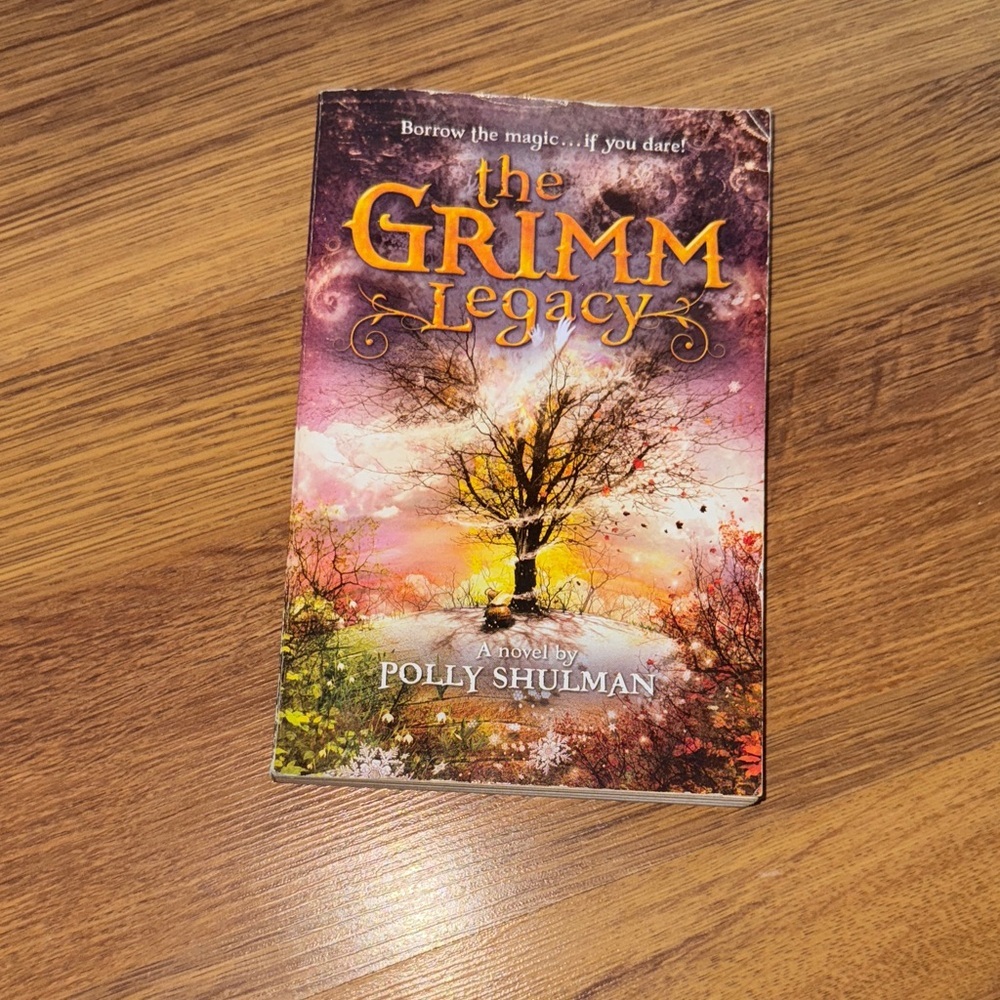 Scholastic The Grimm Legacy Book - Purple and Orange Cover